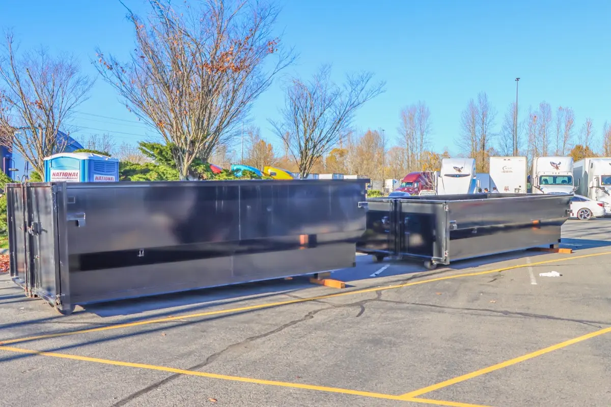 Professional dumpster rental service with roll-off container on residential driveway in Manchester